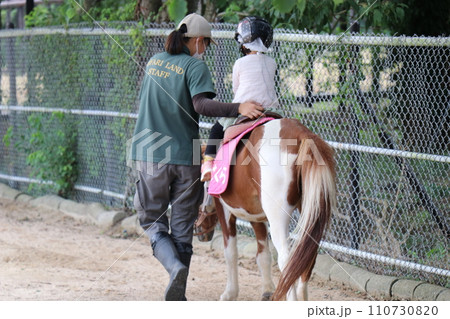 【山口県】秋吉台自然動物公園サファリランド、ふれあい広場、乗馬体験をする子供 110730820