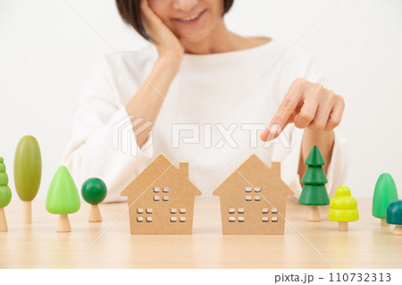 家と微笑むミドル女性 家と微笑むミドル女性 110732313