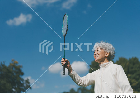 屋外でバドミントンをする60代女性 110733623