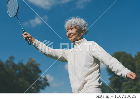屋外でバドミントンをする60代女性 屋外でバドミントンをする60代女性 110733625