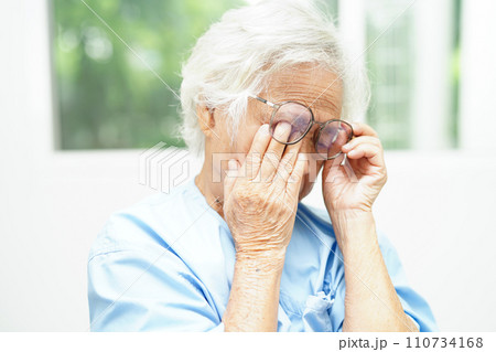 Asian senior woman wearing eyeglasses reduce headache and eyestrain suffer at home care service. Asian senior woman wearing eyeglasses reduce headache and eyestrain suffer at home care service. 110734168