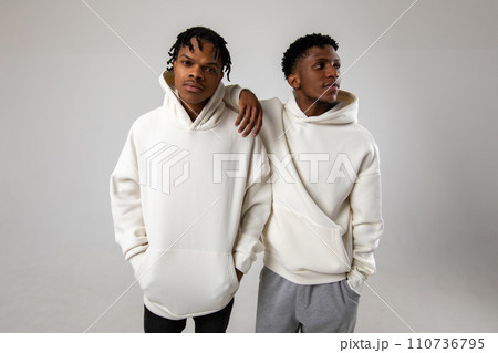 2 African American guys in white hoodies posing on a white background 110736795