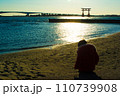 弁天島海浜公園の夕焼けと砂遊びする子どもの後ろ姿 110739908