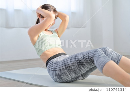 クランチで腹筋を鍛える女性	 110741314