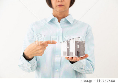 戸建ての住宅模型を指差すミドル女性 110742368