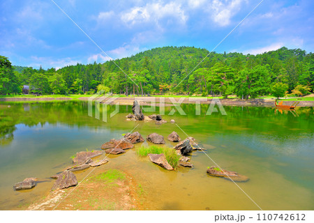 東北・平泉・毛越寺浄土庭園・日本庭園の見どころ、青空を映し出す大泉が池と出島石組、池中立石(3) 110742612