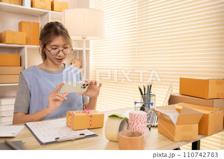 Take product photos, Asian Entrepreneur Working from Home, Sell products online, Working at Home: Online Store Management and Package Delivery. 110742783