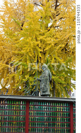 大阪市　紅葉のイチョウの前に立つ聖徳太子創建の四天王寺の弘法大師千躰像　1857 110744335