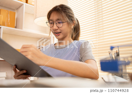 Check the product list, Online selling business, Small business owners are checking inventory in order to prepare them for proper delivery to customers,  Working from Home. 110744928