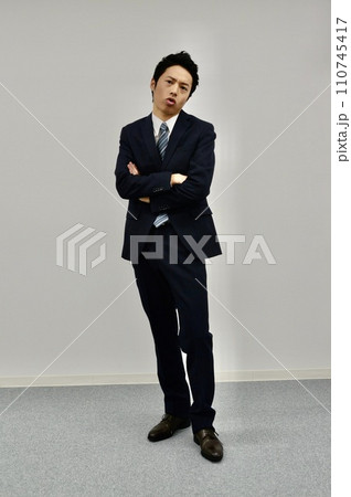 腕を組んで不満顔の若い男性 110745417