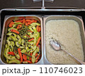 The restaurant has a variety of vegetables and rice in metal containers 110746023