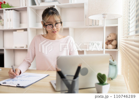 Businesswoman analyzes data graphs and works intently in his personal office, Employees working in the office, Businessman at Desk. Businesswoman analyzes data graphs and works intently in his personal office, Employees working in the office, Businessman at Desk. 110746289