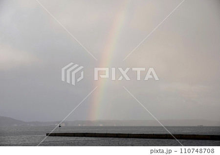 海に突き出た突堤と虹 110748708