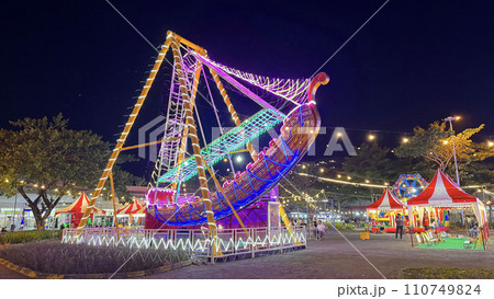 illuminated pirate ship swing boat ride in the amusement recreation park, Christmas market 110749824