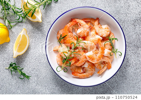 Shrimps with rosemary and lemon on a plate. Healthy food, seafood. Top view 110750524