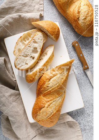 Bread, baguette sliced on a board, top view 110750528