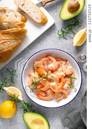 Shrimps with rosemary and lemon on a plate. Healthy food, seafood. Top view 110750529