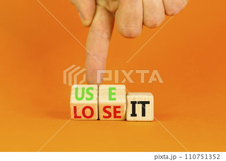 You use or lose it symbol. Concept word Use It or lose it on wooden cubes. Beautiful orange table orange background. Businessman hand. Business and you use or lose it concept. Copy space. You use or lose it symbol. Concept word Use It or lose it on wooden cubes. Beautiful orange table orange background. Businessman hand. Business and you use or lose it concept. Copy space. 110751352