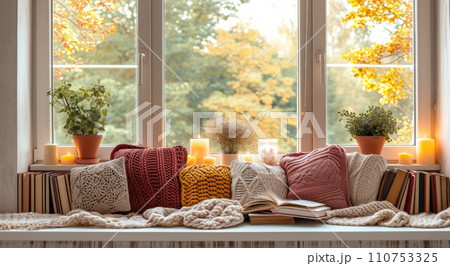 a window with pillows, books and candles 110753325