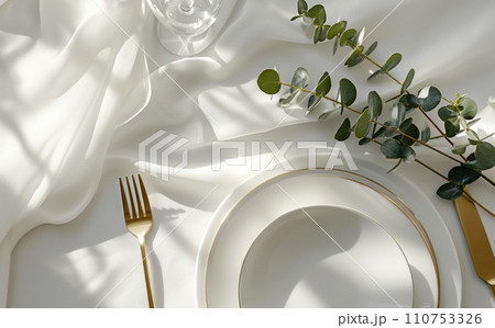 a dining table with place setting and eucalyptus tree leaf 110753326
