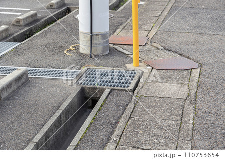 側溝のグレーチング蓋とコンクリート蓋と駐車場の車止め 110753654