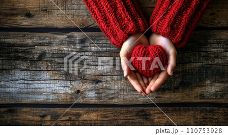 hands in red sweater and red heart on wooden background hands in red sweater and red heart on wooden background 110753928