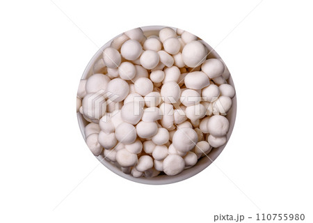 Small white edible beech mushrooms with salt and spices on a plain background Small white edible beech mushrooms with salt and spices on a plain background 110755980