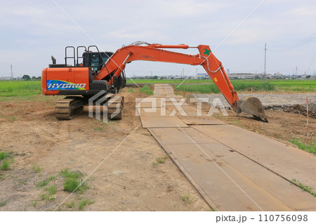 土木工事現場の出入り制限をするパワーショベル 土木工事現場の出入り制限をするパワーショベル 110756098