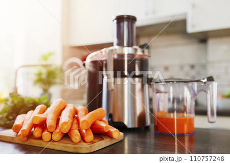 Fresh Carrot Juice Preparation with Juicer at Home 110757248