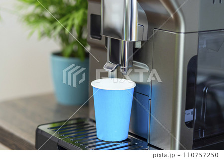Blue Cup Ready for Fresh Brew from Modern Coffee Machine 110757250