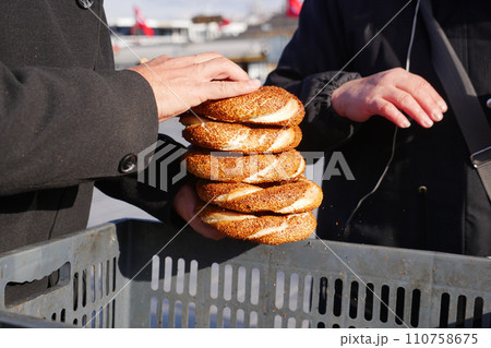 men holding stack of Turkish Bagel Simit  110758675