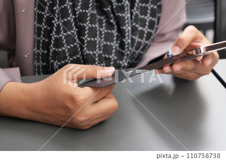 women hand holding credit card and using smart phone shopping online women hand holding credit card and using smart phone shopping online 110758738