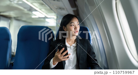 Beautiful Asian businesswoman using mobile phone in aeroplane. working, travel, business concept 110759967