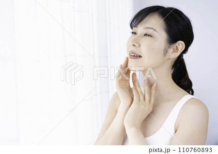 肌の潤いを実感する30代の女性 110760893