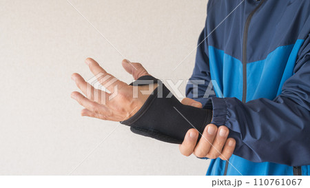 手首・親指のサポーターをする男性 110761067