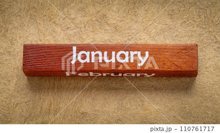 January and February text on wooden block against handmade bark paper in earth tones, calendar concept January and February text on wooden block against handmade bark paper in earth tones, calendar concept 110761717