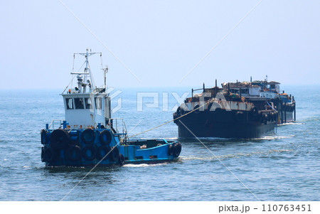 艀を曳航する小型のタグボート 110763451