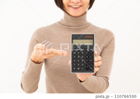 黒い電卓を指差して微笑むミドル女性 110766500