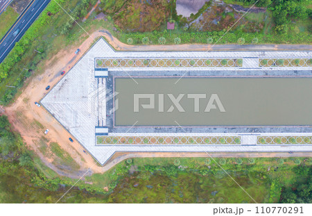 Aerial top view of arrow direction shape with garden park with green mangrove forest trees, river, pond or lake. Nature landscape background, Thailand. Aerial top view of arrow direction shape with garden park with green mangrove forest trees, river, pond or lake. Nature landscape background, Thailand. 110770291