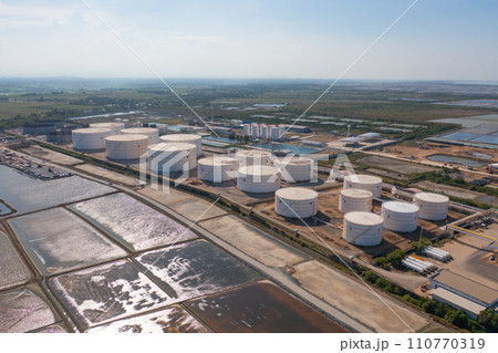 Aerial view of petrochemical oil refinery and sea in industrial engineering concept in Bangna district, Bangkok City, Thailand. Oil and gas tanks pipelines in industry. Modern metal factory. Aerial view of petrochemical oil refinery and sea in industrial engineering concept in Bangna district, Bangkok City, Thailand. Oil and gas tanks pipelines in industry. Modern metal factory. 110770319