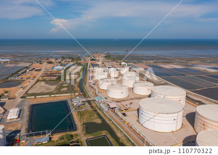 Aerial view of petrochemical oil refinery and sea in industrial engineering concept in Bangna district, Bangkok City, Thailand. Oil and gas tanks pipelines in industry. Modern metal factory. Aerial view of petrochemical oil refinery and sea in industrial engineering concept in Bangna district, Bangkok City, Thailand. Oil and gas tanks pipelines in industry. Modern metal factory. 110770322