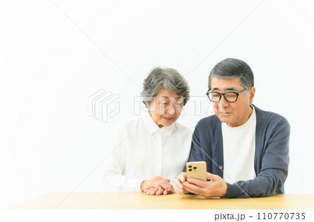 スマートフォンを操作する仲良しシニア夫婦　 110770735