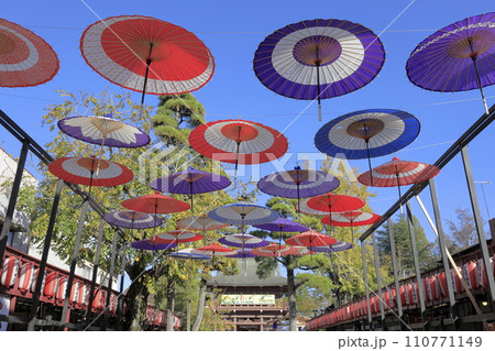 快晴の青空を背景に笠間稲荷の参道に浮かぶ色とりどりの和傘 快晴の青空を背景に笠間稲荷の参道に浮かぶ色とりどりの和傘 110771149