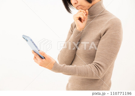 スマホを操作しながら悩むミドル女性 スマホを操作しながら悩むミドル女性 110771196