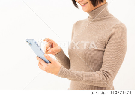 スマホを操作しながら微笑むミドル女性 スマホを操作しながら微笑むミドル女性 110771571