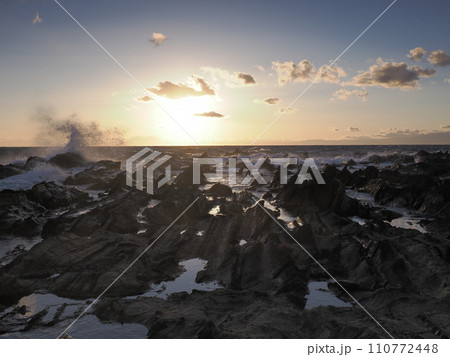 冬の海岸に沈む夕陽 110772448
