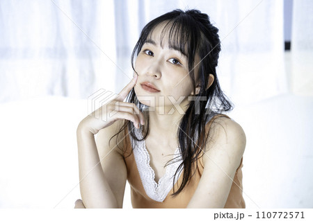 ラフな服装でくつろぐフェミニンな雰囲気の若い女性 110772571