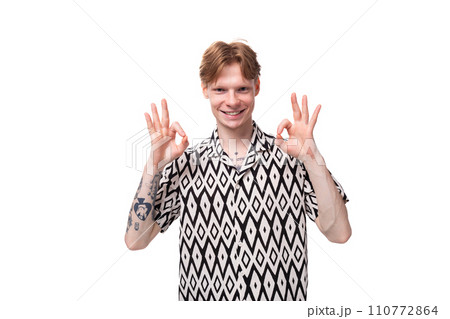 young smiling red-haired man dressed in a summer short-sleeved shirt in black and white young smiling red-haired man dressed in a summer short-sleeved shirt in black and white 110772864