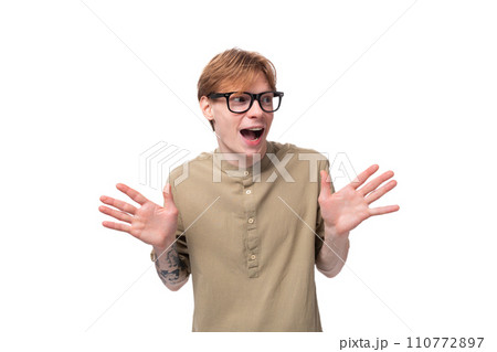 young cute caucasian guy with red hair with a tattoo on his arm in a brown shirt young cute caucasian guy with red hair with a tattoo on his arm in a brown shirt 110772897