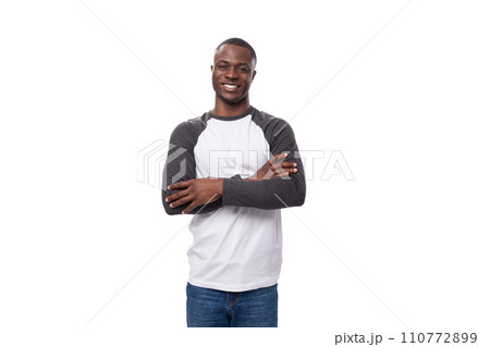 young well-groomed African guy dressed in a black-and-white sweatshirt and jeans in the studio on a young well-groomed African guy dressed in a black-and-white sweatshirt and jeans in the studio on a 110772899